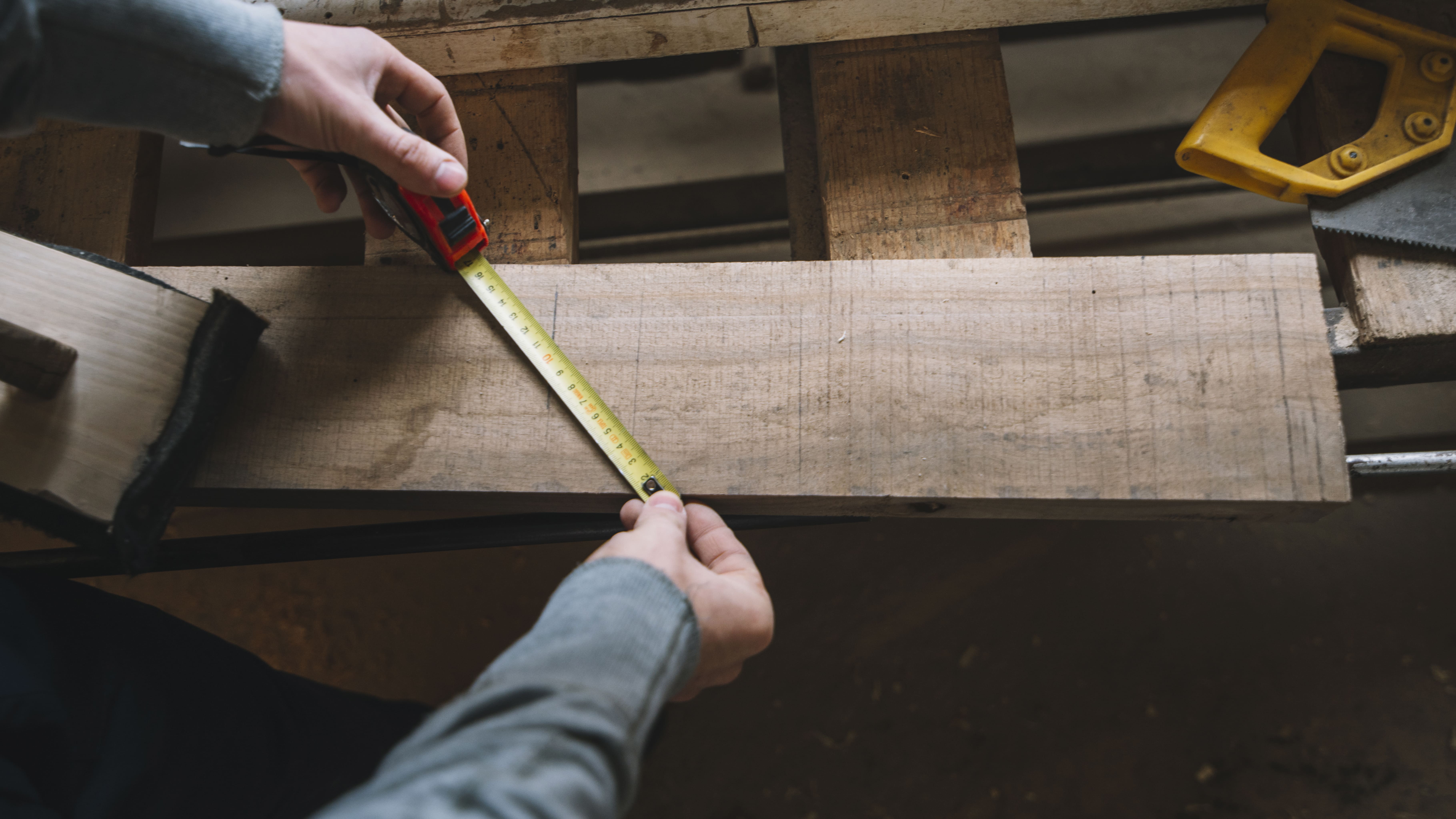 Carpenter measuring wood with precision